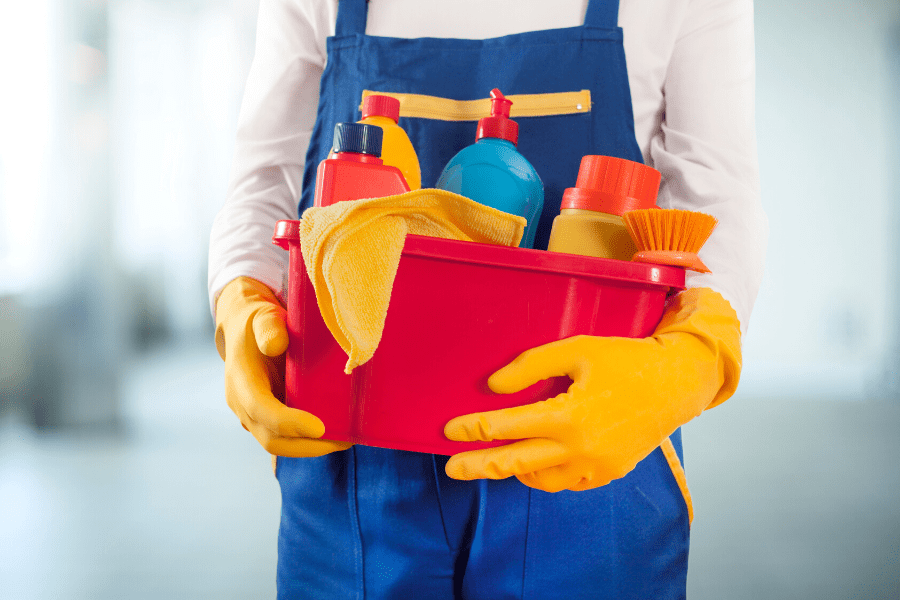 clean the siding. Person holding a bucket of cleaning supplies