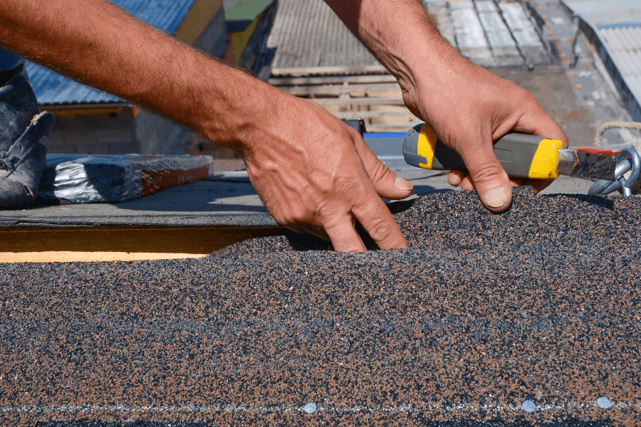 getting a new roof. Man installing shingles on a roof