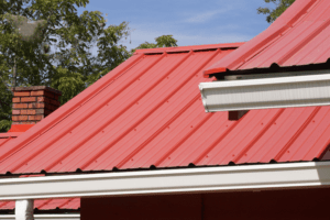 Maintenance for Metal Roofs showing a red metal roof with white gutters.